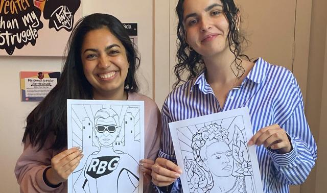 Two women holding artwork from a CRWN event