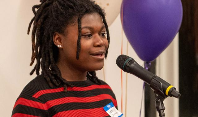 Woman speaking at the mic at a CRWN event